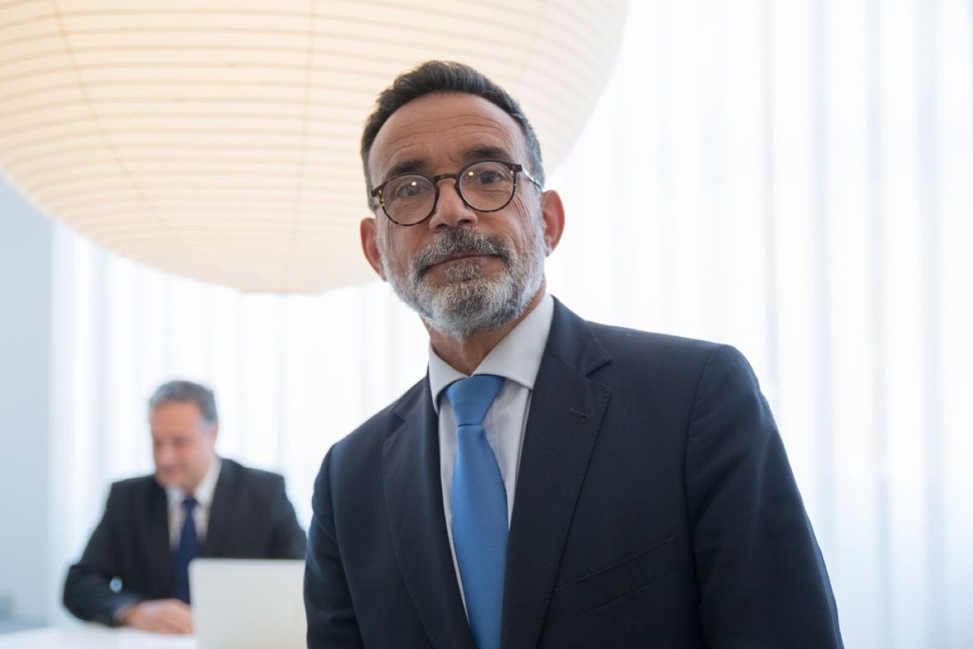Richard H. Calder, a gray-bearded man in glasses and a dark suit, in a bright office